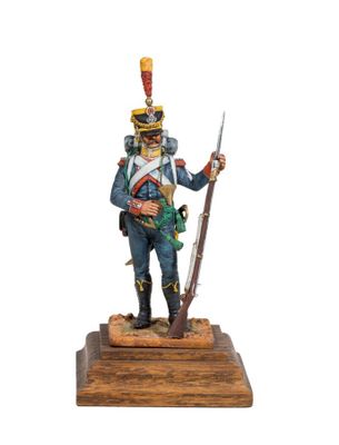 statue of a soldier in uniform holding a rifle on a wooden base