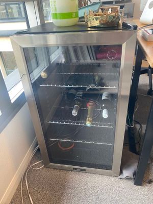 un petit refroidisseur à vin posé dans un coin de la pièce