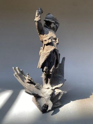 une statue représentant un homme tenant un oiseau dans la main
