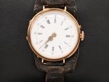 un gros plan d'une montre-bracelet posée sur un coussin noir