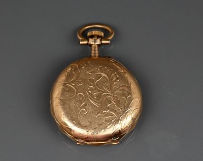 une montre de poche en or posée sur une table