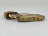 an old pocket knife sitting on top of a white surface