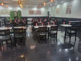 Il y a beaucoup de tables et de chaises vides dans ce restaurant.