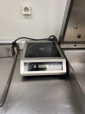 un plan de travail en acier inoxydable équipé d'une cuisinière et d'un évier dans une cuisine
