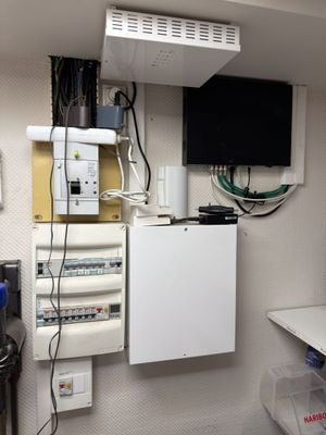 une photo d'une pièce avec un réfrigérateur, une télévision et d'autres appareils électriques