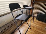 a black folding chair sitting in front of a window