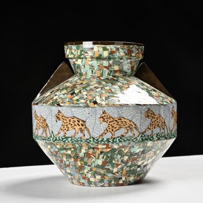 a vase that has giraffes on it on a table