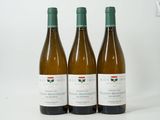 three bottles of wine sitting on top of a white table