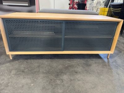 une armoire en bois surmontée de perforateurs, dans un entrepôt