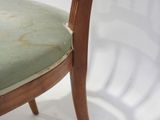 a close up of a wooden chair with a green seat