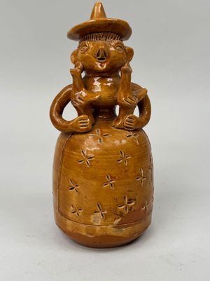 une image représentant un vase marron surmonté d'un singe
