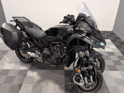 une moto noire garée sur un sol à damier