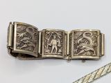 a close up of a silver bracelet with a dragon on it