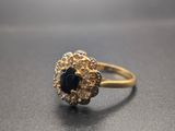 gros plan d'une bague en or avec une pierre noire
