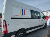 un homme debout à côté d'une camionnette blanche sur un parking
