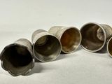 four silver cups are lined up in a row on a white surface