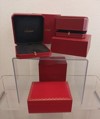 three red boxes are stacked on top of each other in a display case