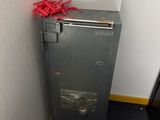 une poubelle à côté des toilettes dans une petite pièce