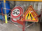many different road signs on a rack in a garage