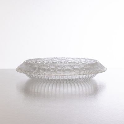 un saladier en verre posé sur une table, avec un mur blanc en arrière-plan