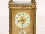 a gold clock that is sitting on a white surface