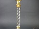 une image représentant une lampe de table en or et en cristal sur fond noir