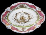 une assiette sur laquelle est représenté un oiseau, sur fond noir
