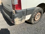 a white van with a flat tire parked in a parking lot