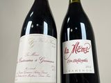 two bottles of wine sitting next to each other on a table