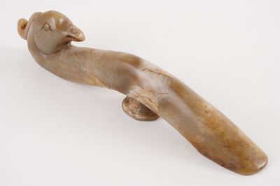 a small figurine of a bird on a white surface