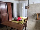 a room with a table, chairs, and a refrigerator in it