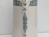 a white vase with a black and white design on it
