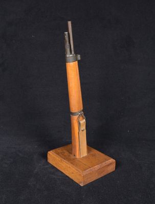 un petit objet en bois surmonté d'un couteau