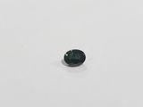a green sapphire stone on a white surface