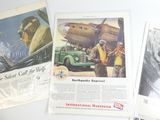 Plusieurs anciennes publicités sont exposées sur une table devant un fond blanc.