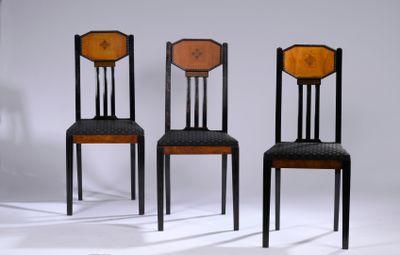 trois chaises noires avec une assise marron et un dossier noir