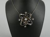 un collier noir et blanc orné d'un motif floral, porté par un mannequin