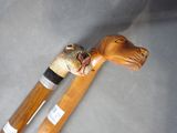 a wooden walking stick with a carved animal head on it
