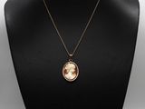 un collier sur lequel est représentée une femme, porté par un mannequin