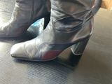 someone is wearing a pair of high heeled boots on a table