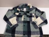 blue and white checkered jacket on a white table next to a wall