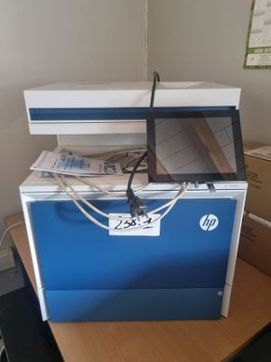 une imprimante posée sur une boîte, elle-même posée sur un bureau