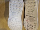 a pair of white shoes that are on a wooden floor