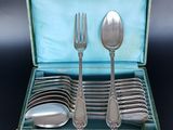 a green case with silverware in it on a black surface