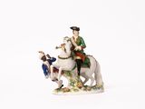 une figurine représentant un homme à cheval accompagné d'un chien