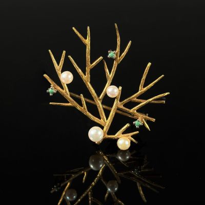 a close up of a gold tree brooch with pearls and emeralds