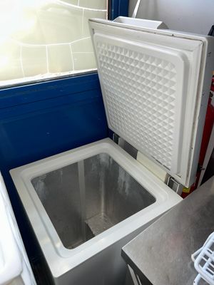 un petit réfrigérateur posé dans un coin de la cuisine