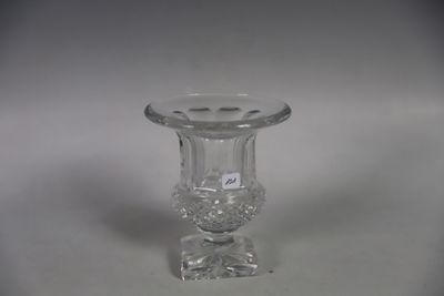 un vase en verre transparent avec un socle transparent posé sur une surface blanche