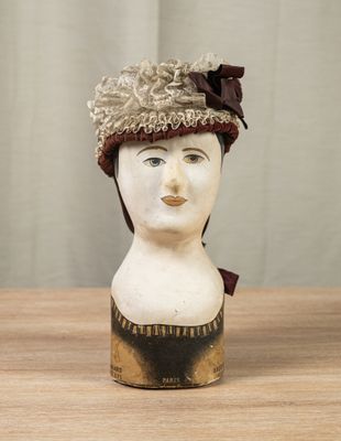 a ceramic head of a woman with a hat on it