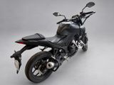 a black motorcycle that is parked on a gray surface